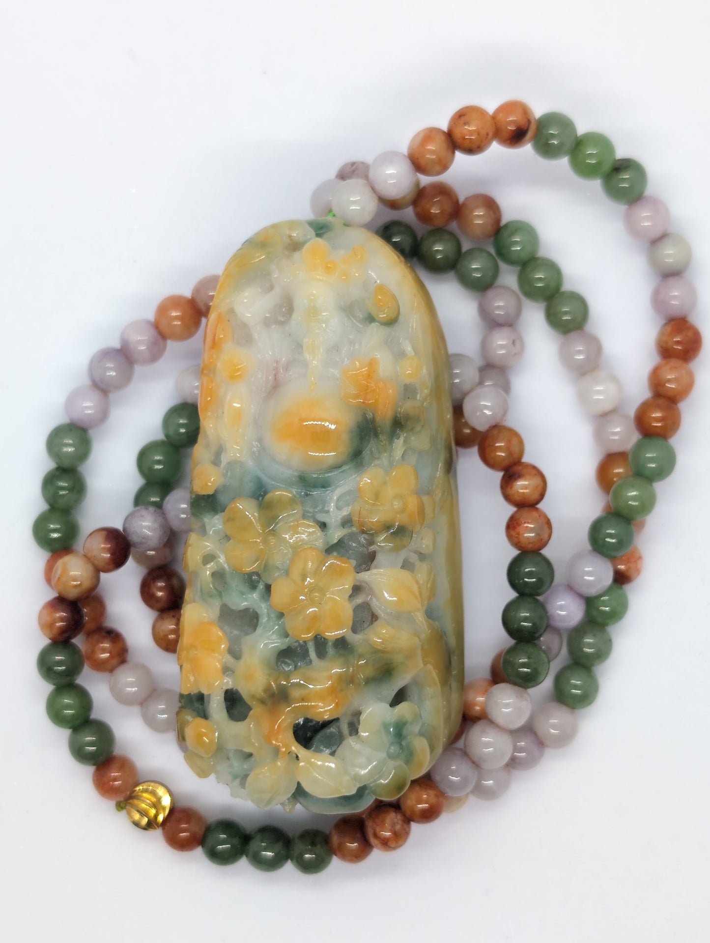 A teardrop-shaped jadeite pendant with a floral pattern in green, yellow, and orange-red colors, accompanied by a multicolor jadeite beads necklace.