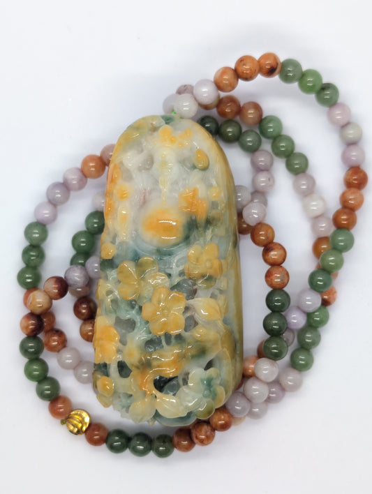 A teardrop-shaped jadeite pendant with a floral pattern in green, yellow, and orange-red colors, accompanied by a multicolor jadeite beads necklace.